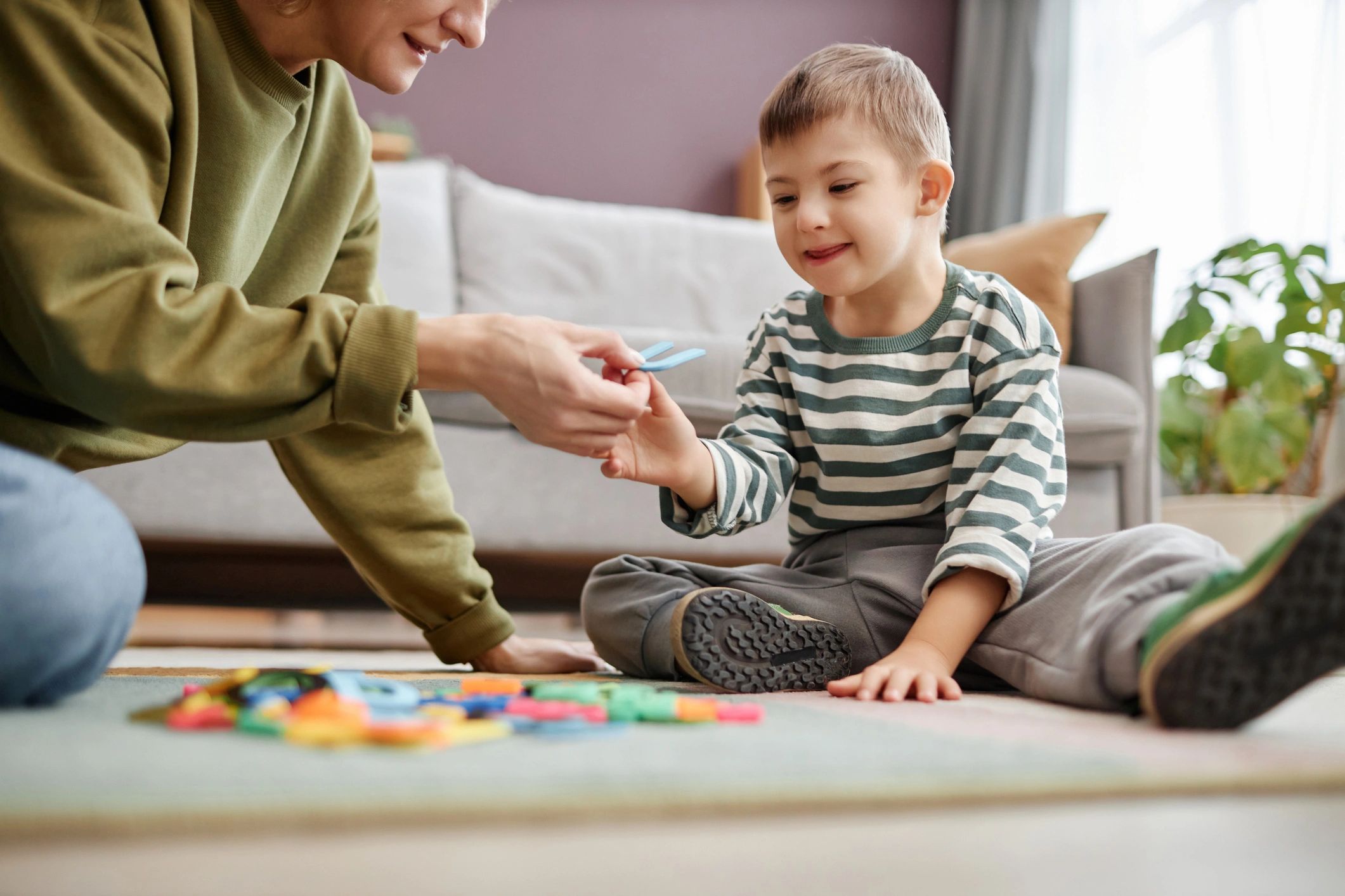 Child learning with letter tiles during a therapy activity