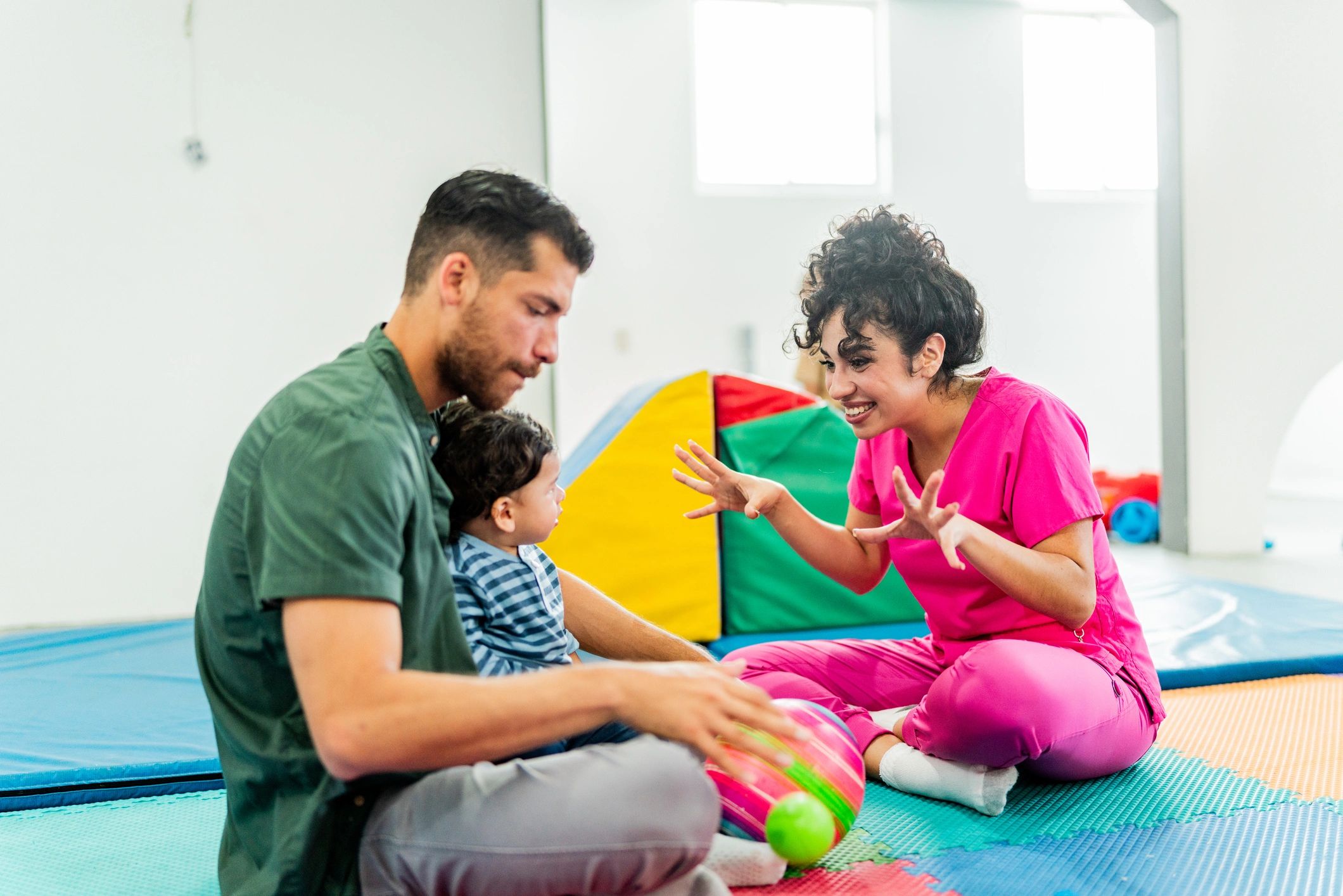 Clinician speaking with a parent and child in a clinic setting