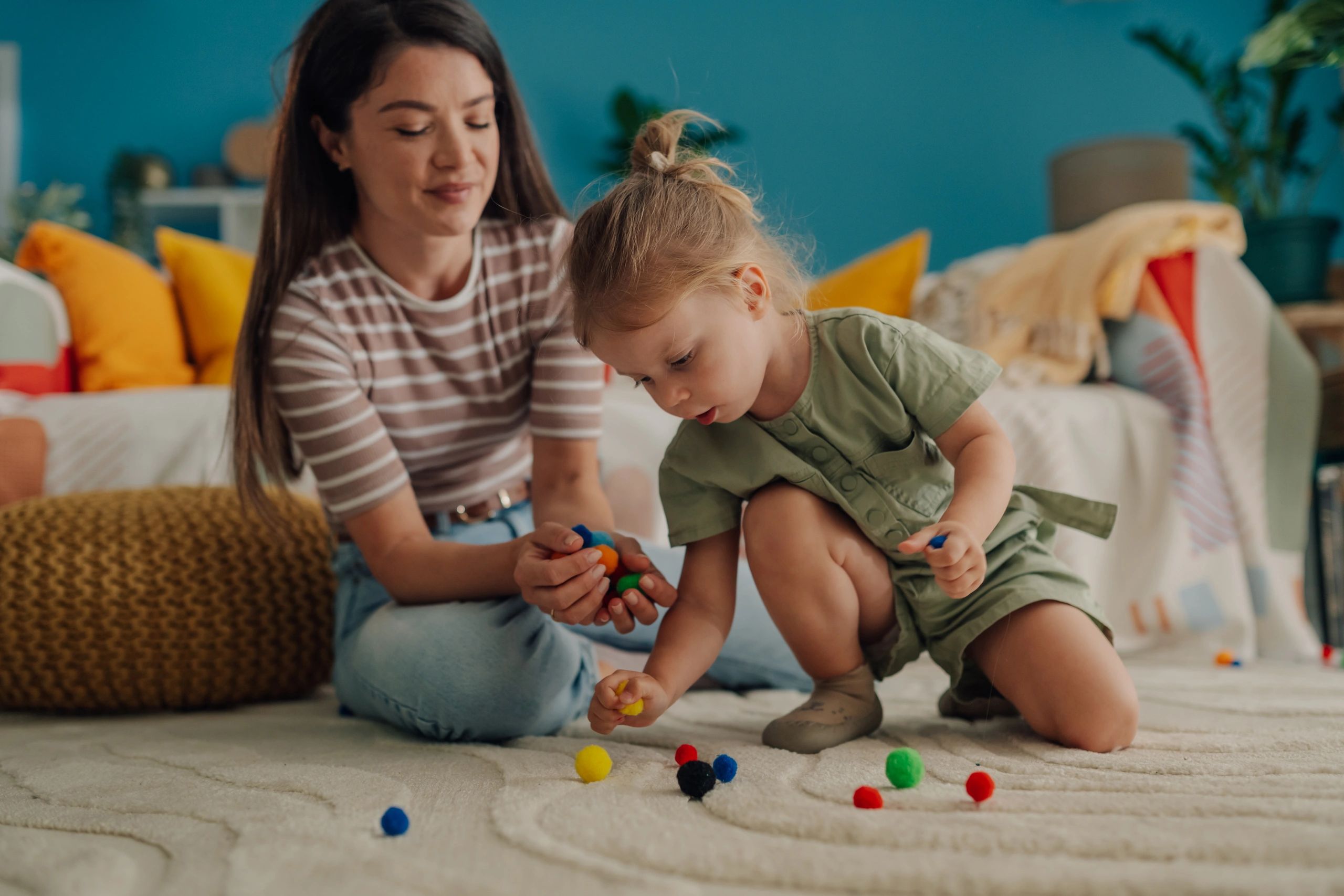 Child sorting colorful pom-poms during a fine motor activity