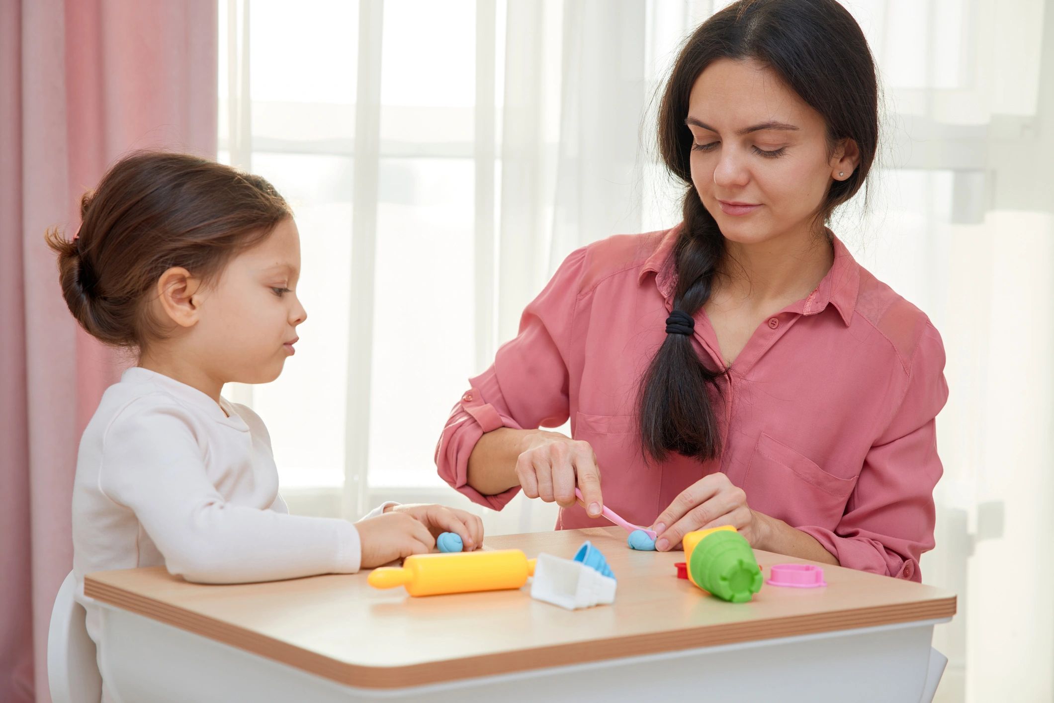 Parent and child playing with modeling clay for hand strength